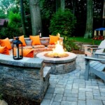 A fire pit with orange pillows and benches