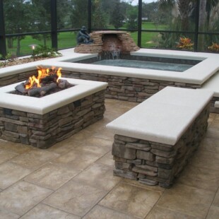 A fire pit with stone benches and a hot tub.