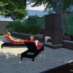 A couple of people sitting on lounge chairs in the backyard.