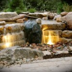 A waterfall with lights on the side of it