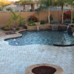 A pool with a fire pit and waterfall in the middle of it.