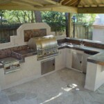 A large outdoor kitchen with an oven and grill.