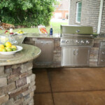 A large outdoor kitchen with an island and grill.