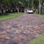 A driveway with brick and grass in it