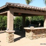 A stone and brick outdoor kitchen with an open roof.