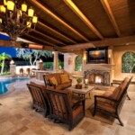 A patio with couches, chairs and a fireplace.