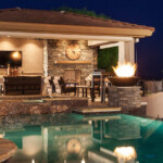 A pool with an outdoor fireplace and fire pit.