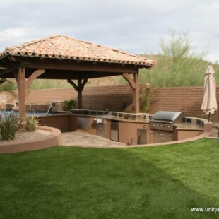 A gazebo with an outdoor kitchen and grill.