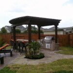 A patio with an outdoor grill and table.