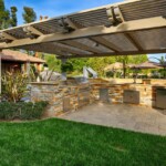 A patio with an outdoor kitchen and a pergola.