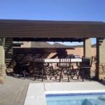 A patio with a table and chairs next to the pool.
