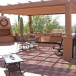 A patio with chairs, tables and an outdoor fireplace.