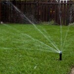 A lawn with water sprinklers on it